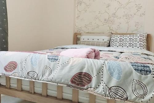 a bed with a blanket and pillows on it at Cozy apartment Maadi Ring road in Cairo