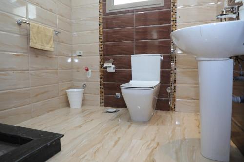 a bathroom with a white toilet and a sink at Luxurious apartment - New Cairo in Cairo