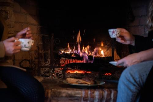 a group of people drinking coffee in front of a fireplace at Masseria D'Achille in Castel di Sangro