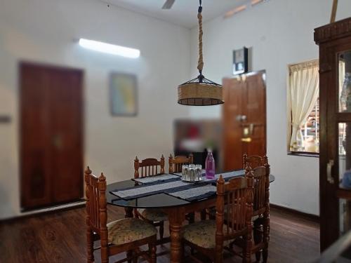 a dining room table and chairs in a room at Anandam Stays - Premium 3BHK plush homestay, Vaikom near Kumarakom in Vaikom