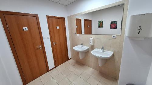 Baño con 2 lavabos y espejo en Hostel CANTO, en Ruse