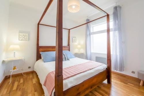 1 dormitorio con cama con dosel y ventana en Les Gîtes de Nathalie: Corneille et Rivals, en Carcassonne