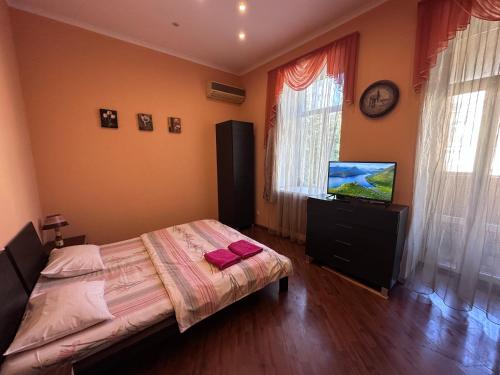 キーウにあるKyivStay Yaroslavska Apartmentのベッドルーム(ベッド1台、薄型テレビ付)