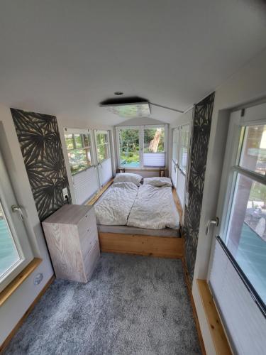 a bed in a small room with windows at Seychellen House in Großenkneten