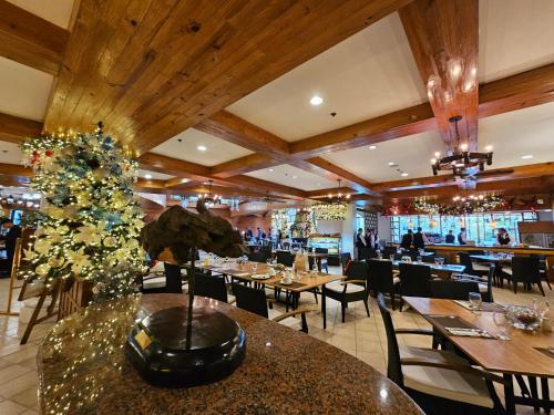 un restaurante con mesas y un árbol de Navidad en el medio en Forest Lodge at Camp John Hay privately owned - Deluxe Queen Suite with balcony and Parking 269 en Baguio
