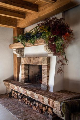 a stone fireplace with flowers on top of it at Masseria D'Achille in Castel di Sangro