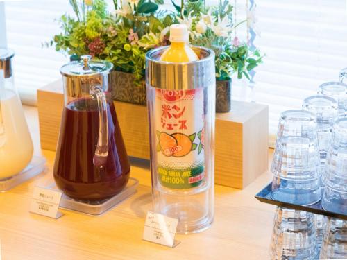 a table with a bottle of honey and a container of liquid at Dormy Inn Matsuyama Natural Hot Spring in Matsuyama