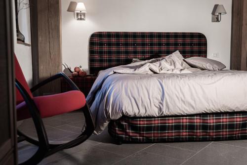 1 dormitorio con 1 cama y 1 silla roja en Masseria D'Achille, en Castel di Sangro