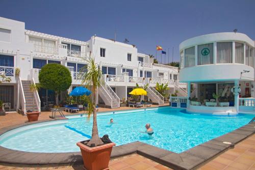 una gran piscina en un hotel con gente dentro en San Francisco Park, en Puerto del Carmen