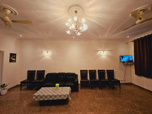 a room with chairs and a table and a chandelier at Raj Residency Inn in Gurgaon