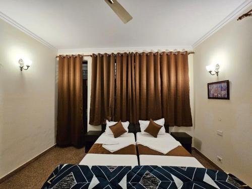 a bedroom with two beds in front of a window at Raj Residency Inn in Gurgaon