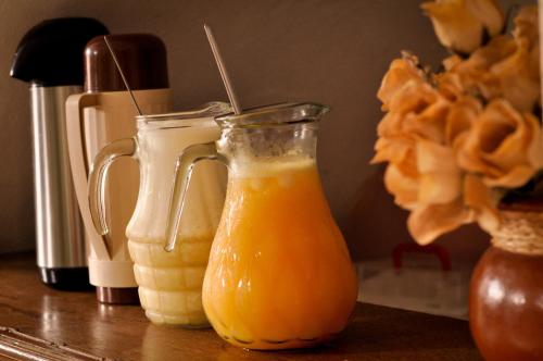 a couple of glass pitchers of orange juice on a table at Pousada Recanto de Minas - no Centro in Tiradentes