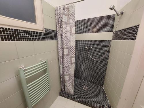 łazienkę z prysznicem wyłożoną czarno-białymi kafelkami. w obiekcie Terrific Tátra Apartment w Budapeszcie