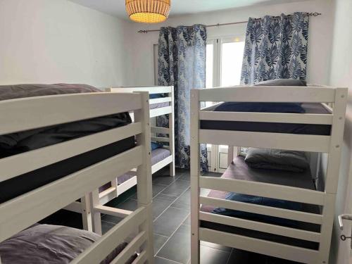 a room with two bunk beds and a window at Villa Bois Court 3 chambres in Le Tampon