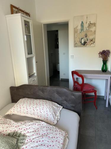 een woonkamer met een bank en een rode stoel bij Kleine zimmer in luxus wohnung in Schenefeld