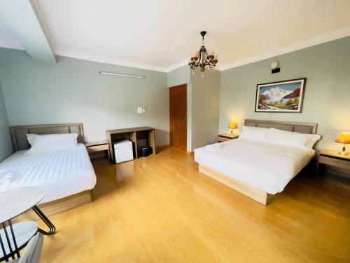 1 Schlafzimmer mit 2 Betten und Holzboden in der Unterkunft maharajgunj Chakrapath in Kathmandu