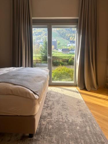 a bedroom with a bed and a large window at Hotel DRAŠ in Maribor