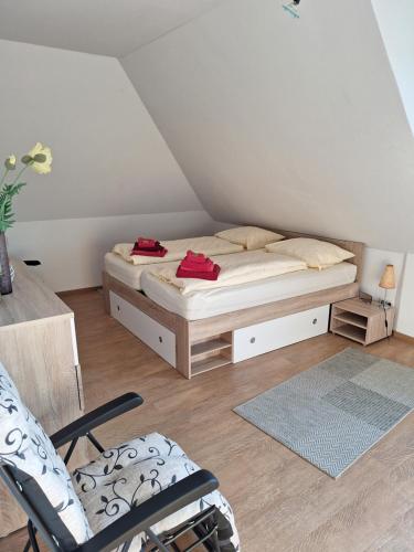 ein Schlafzimmer mit einem Bett und einem Stuhl im Dachgeschoss in der Unterkunft Storchennest in Burg