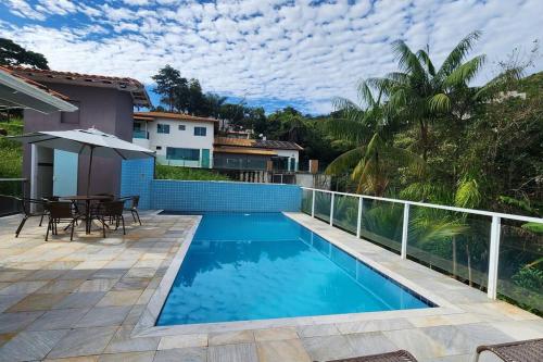 a swimming pool in front of a house at Casa Escarpas do lago in Capitólio