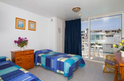 a bedroom with two beds and a view of a balcony at San Francisco Park in Puerto del Carmen