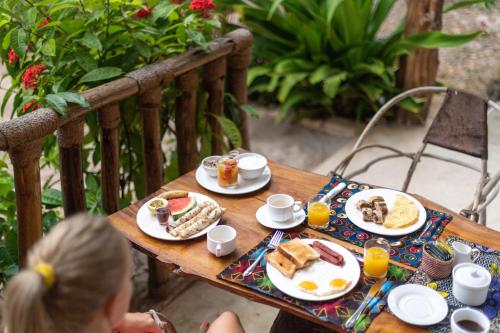 a table with plates of breakfast food on it at Shanuo Beach Bungalows in Michamvi