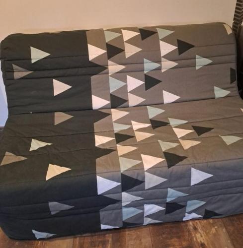 - un canapé avec une couette et des plans en papier dans l'établissement Superbe loft neuf - 1 chambre- face au Château, à Sedan