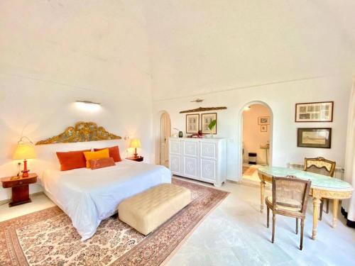 a bedroom with a large bed and a table at Lella Kmar B&B avec piscine Sidi Bou Said in Sidi Bou Saïd