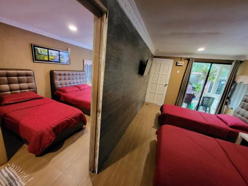 Habitación con 2 camas rojas y espejo. en Tamara Guest House en Tioman Island