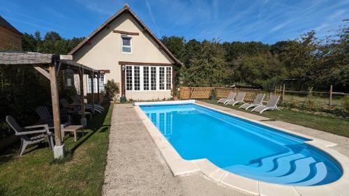 a swimming pool with chairs and a house at Au Bonheur de Cisse in Chouzy-sur-Cisse