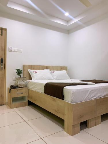 a bedroom with a large bed with a wooden frame at New Thai Residency in Dhārāpuram