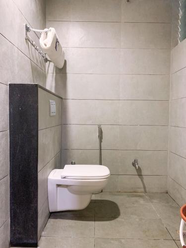 a bathroom with a white toilet in a room at New Thai Residency in Dhārāpuram