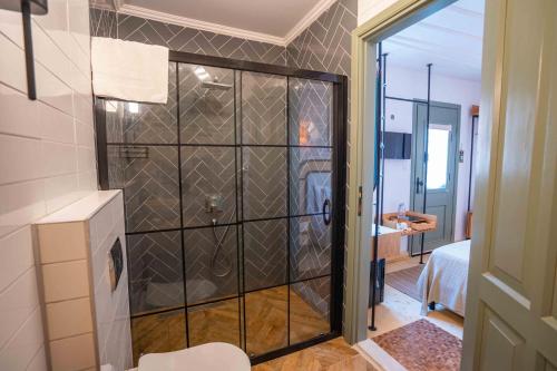 a bathroom with a shower with a glass door at Cundalis1893 in Ayvalık