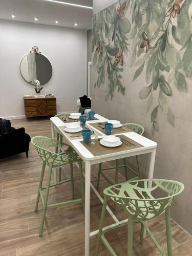 那不勒斯Napoli centro - Di&da guest house的一张桌子、四把椅子和镜子