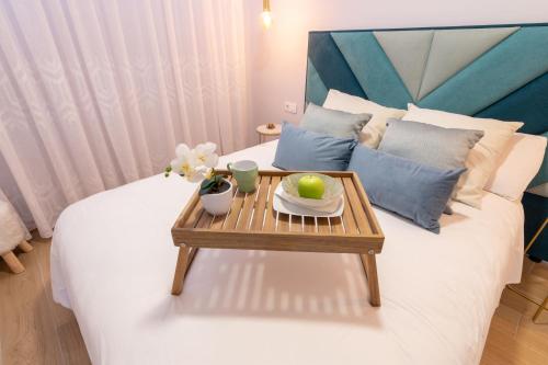 a bed with a tray with a table on it at OASIS PLAYA DEL INGLES 324 by Homestaygrancanaria in San Bartolomé de Tirajana