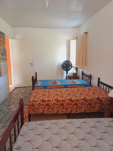 a bedroom with a bed with a colorful bedspread at Vila Neto in Uruçuca