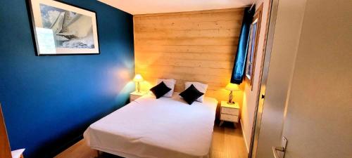 ein Schlafzimmer mit einem weißen Bett mit blauen Wänden in der Unterkunft La voute de Montchavin in Montchavin