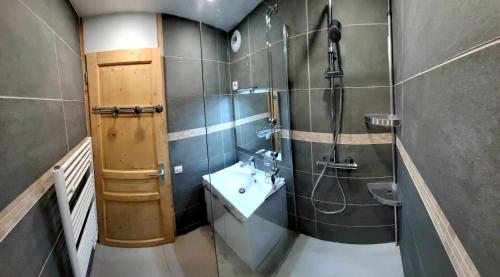 ein Bad mit einem Waschbecken und einer Dusche in der Unterkunft La voute de Montchavin in Montchavin
