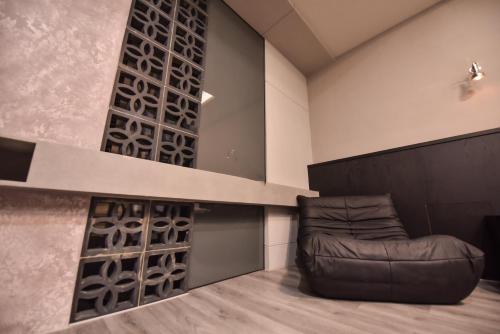 a living room with a leather couch in a room at Two Couples Leisure Art Motel in Tainan