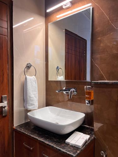 a bathroom with a white sink and a mirror at Vyom Boutique Hotel Rishikesh in Rishīkesh