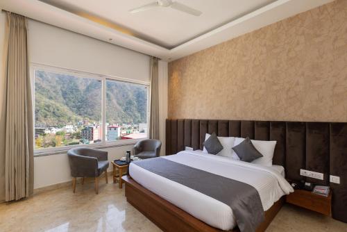 a bedroom with a large bed and a large window at Vyom Boutique Hotel Rishikesh in Rishīkesh