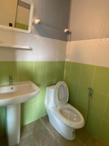 a bathroom with a white toilet and a sink at Phi Phi Goodview Bungalow in Phi Phi Islands