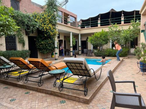 - un groupe de chaises assises à côté de la piscine dans l'établissement Riad Rime Garden Marrakech, à Marrakech