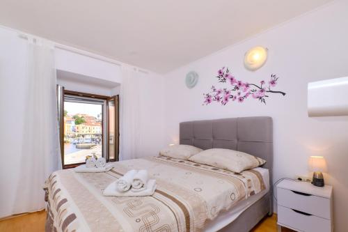 a bedroom with a bed with towels on it at Apartments Antonella in Veli Lošinj