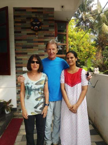 a man and two women standing in front of a house at PRAKRITI HOMESTAY Fortkochi Air Conditioned Rooms in Cochin