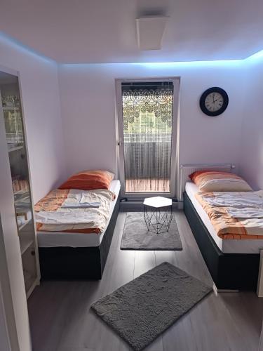 a bedroom with two beds and a clock on the wall at Apartment mit Ausblick in Braunschweig