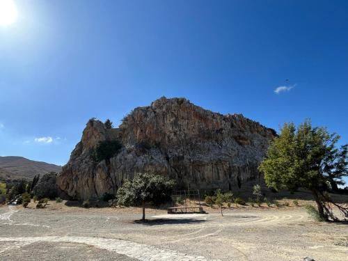 a bench in front of a large rocky mountain at Katerina's Rest Stone Ηouse in Khárakas