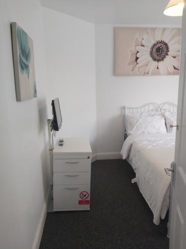 a bedroom with a white bed and a white dresser at Fresher Space Home Stay in Birmingham