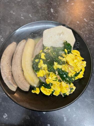 a plate of food with sausage and vegetables on a table at The Lodge @ Peaceful Palms in Montego Bay