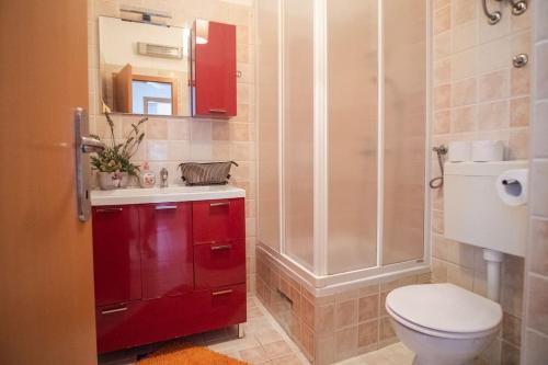a bathroom with a red sink and a toilet at Apartman Tino with two sunny terace in Hvar