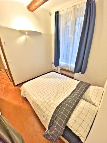 un lit dans une chambre avec une fenêtre dans l'établissement Vieux-Port : Appartement Cozy, Calme et Pratique, à Marseille